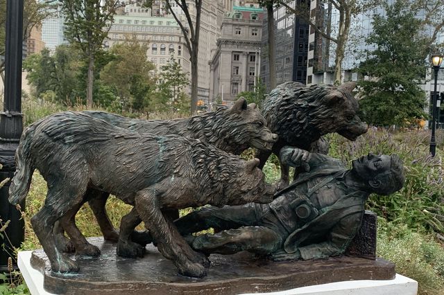 This is a photo of a hoax monument featuring three wolves menacing a man.